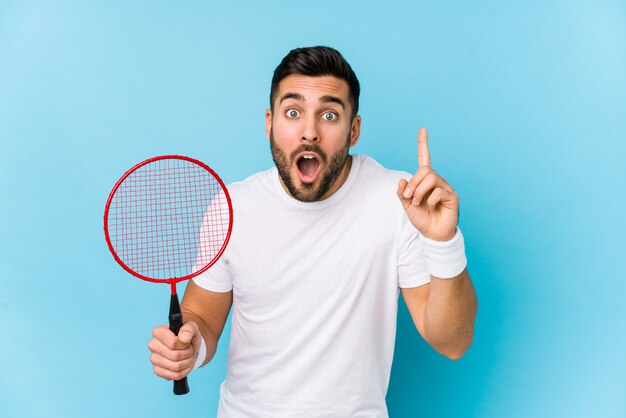 Der junge gutaussehende Mann, der Badminton spielt, lokalisierte das Haben einer Idee, Inspirationskonzept.