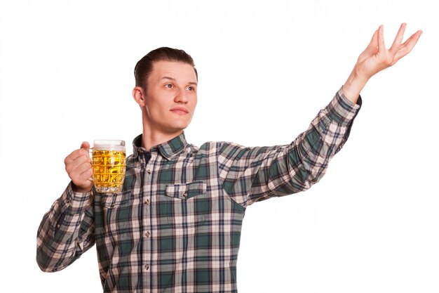 Der junge gutaussehende Mann, der weg schaut, aufwerfend mit einem Glas Bier, Kopienraum auf der Seite. Mann, der das Oktoberfest getrennt auf Weiß feiert