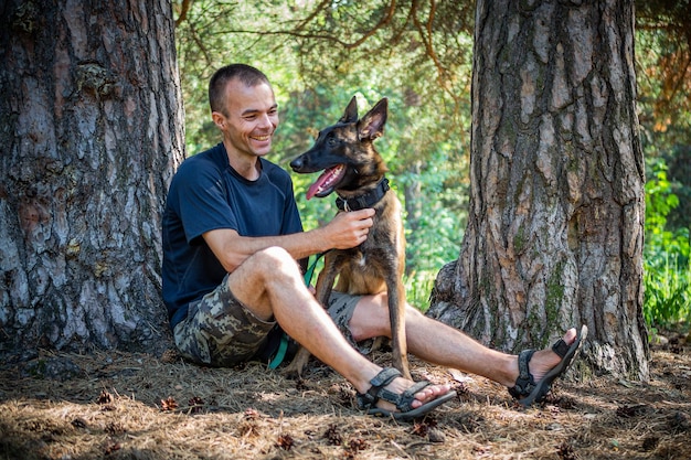 Der junge kaukasische Hipster verbringt an einem sonnigen Sommertag Zeit mit seinem Hund im Park Das Konzept eines Haustieres als Familienmitglied