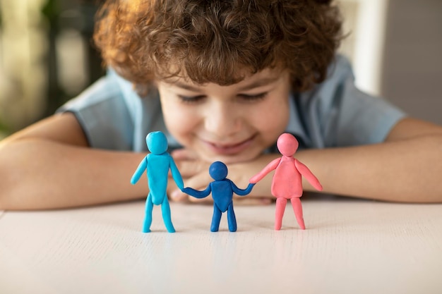 Foto der junge machte figuren von menschen aus dem konzept der plastilin-vater-mutter-kind-familienbeziehungen