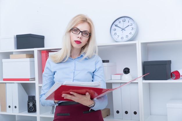 Der junge Manager bewahrt einen Ordner mit Dokumenten im Büro auf