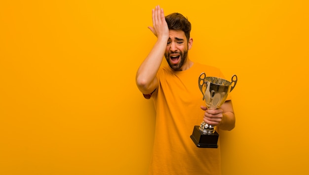 Der junge Mann, der eine Trophäe vergesslich hält, verwirklichen etwas