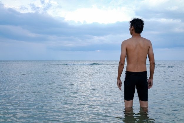 Foto der junge mann im meer drehte sich um.