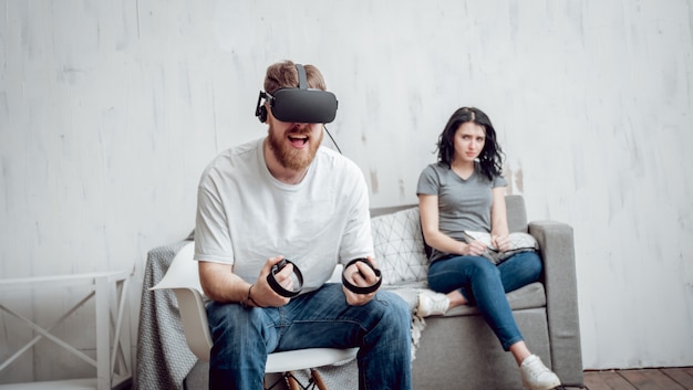 Der junge Mann mit Freundin spielt Spiele mit Virtual-Reality-Brille