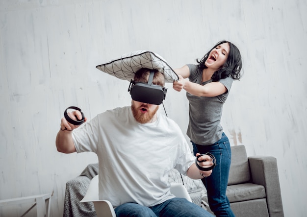 Der junge Mann mit Freundin spielt Spiele mit Virtual-Reality-Brille