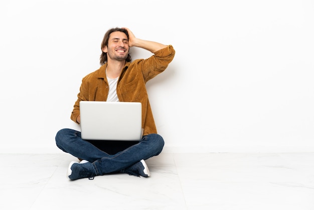 Der junge Mann mit seinem Laptop auf dem Boden hat etwas erkannt und beabsichtigt, die Lösung zu finden