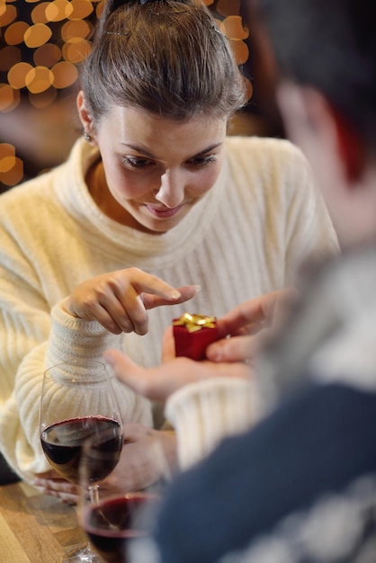 Der junge Mann schenkt dem Mädchen im Restaurant einen Ehering