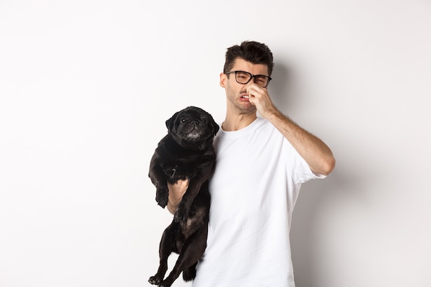 Der junge Mann schloss die Nase als Mops, angewidert von dem üblen Geruch eines Tierfurzes, der über Weiß stand