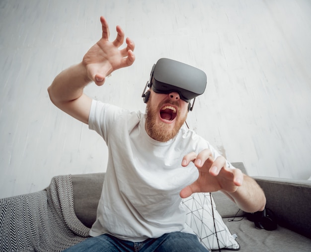 Der junge Mann spielt Spiele mit Virtual-Reality-Brille