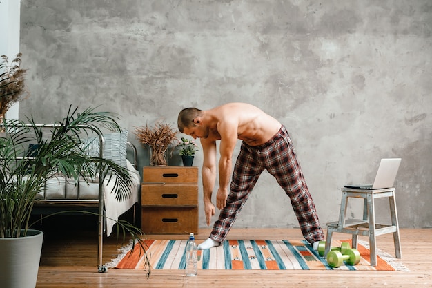 Der junge Mann treibt zu Hause Sport