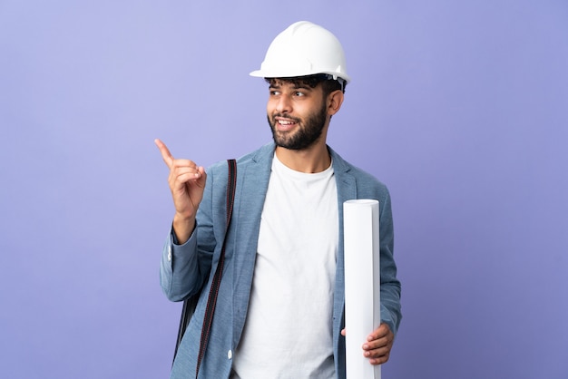 Der junge marokkanische Architekt mit Helm und Blaupausen über die Absicht, die Lösung zu realisieren