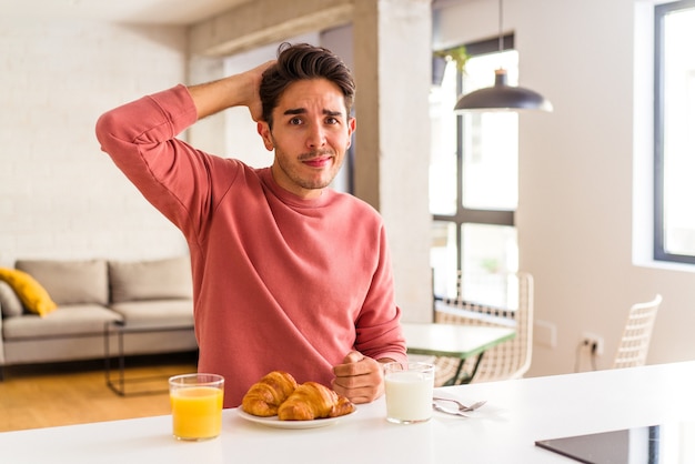 Der junge Mischlingsmann, der am Morgen in einer Küche frühstückt, ist schockiert und hat sich an ein wichtiges Treffen erinnert.