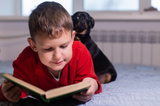 Der Junge mit dem Hund liest ein Buch