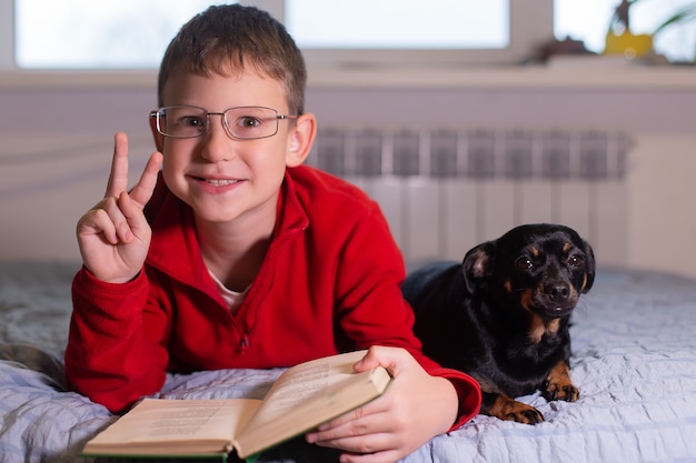 Der Junge mit dem Hund liest ein Buch