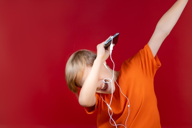 Der Junge mit dem Telefon in der Hand bedeckte seine Augen mit den Ellbogen und bückte sich