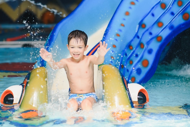 Der Junge rollt mit einer Wasserrutsche in einem Wasserpark in Little Rock