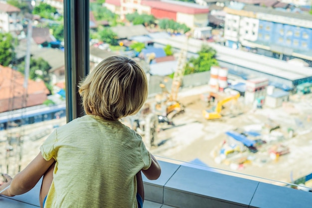 Der Junge schaut sich die Baustelle an. Wählt seinen zukünftigen Beruf