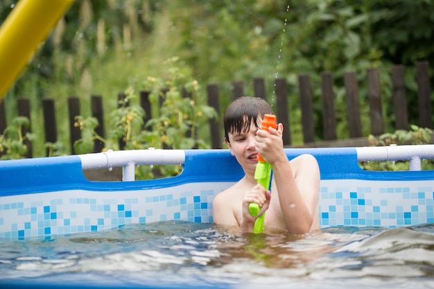 Der Junge schießt aus einer Wasserpistole