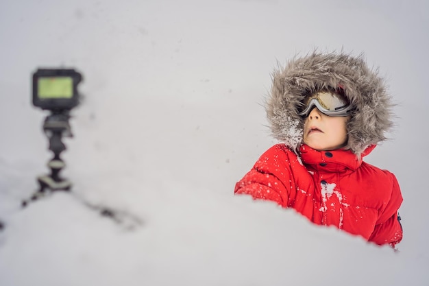 Der Junge schreibt einen Video-Blog-Vlog im Schnee