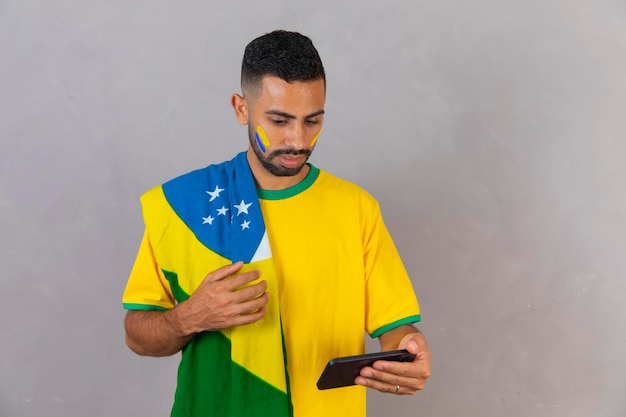 Der junge schwarze Fan Brasiliens ist verzweifelt und nervös und sieht sich das Spiel auf seinem Handy an
