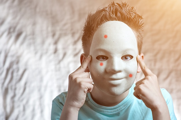 Der Junge setzte eine Maske mit Pickeln auf