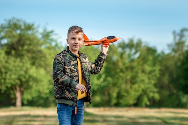 Der Junge startet ein Spielzeugflugzeug.