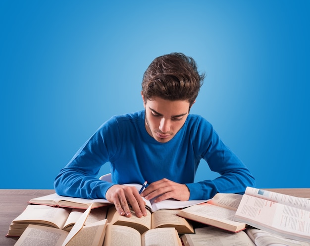 Der junge Student lernt hart auf dem Schreibtisch