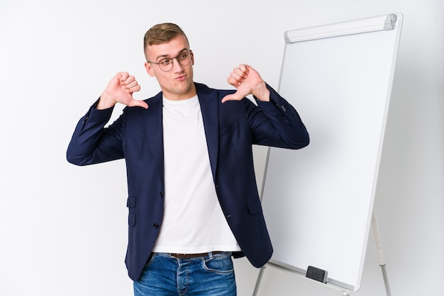 Der junge Trainermann, der ein weißes Brett zeigt, fühlt sich stolz und selbstbewusst, Beispiel zu folgen.