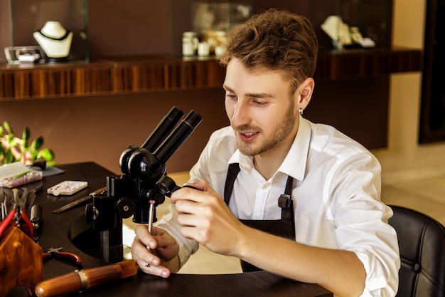 Der Juwelier untersucht den Edelstein unter der Lupe