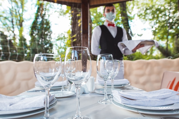 Der Kellner arbeitet in einem Restaurant auf der Sommerterrasse