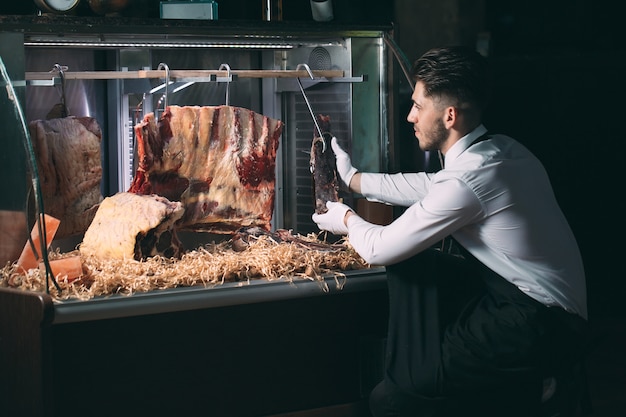 Der Kellner oder Koch bekommt trockenes Fleisch in den Kühlschrank.