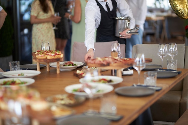 der kellner serviert einen festlichen tisch in einem café mit selektivem fokus