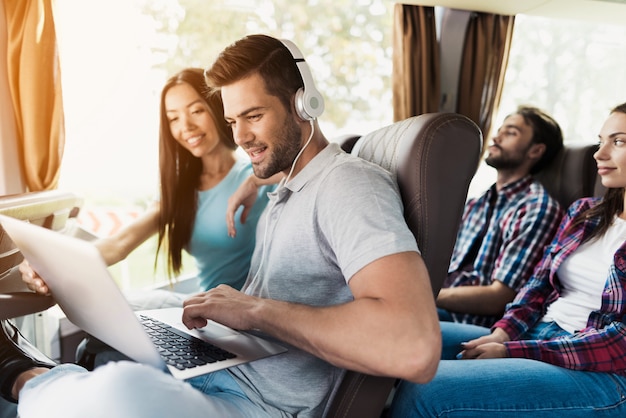 Der Kerl arbeitet an einem Laptop im Bus