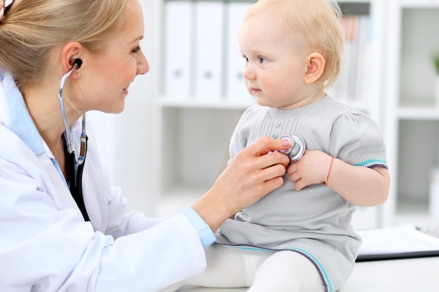 Der Kinderarzt kümmert sich um das Baby im Krankenhaus. Kleines Mädchen wird vom Arzt mit Stethoskop untersucht. Gesundheitsversorgung, Versicherung und Hilfskonzept.