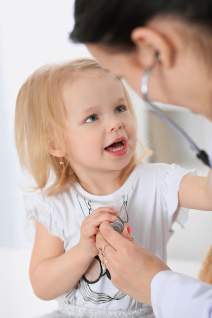 Der Kinderarzt kümmert sich um das Baby im Krankenhaus. Kleines Mädchen wird vom Arzt mit Stethoskop untersucht. Gesundheitsversorgung, Versicherung und Hilfskonzept.