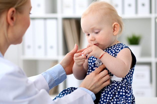 Der Kinderarzt kümmert sich um das Baby im Krankenhaus. Kleines Mädchen wird vom Arzt mit Stethoskop untersucht. Gesundheitsversorgung, Versicherung und Hilfskonzept.