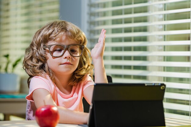 Foto der kleine junge hebt die hand, um die frage des lehrers zu beantworten