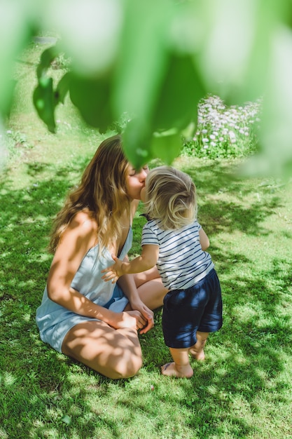 Der kleine Junge küsst seine Mutter. Mama küsst ihr kleines Kind