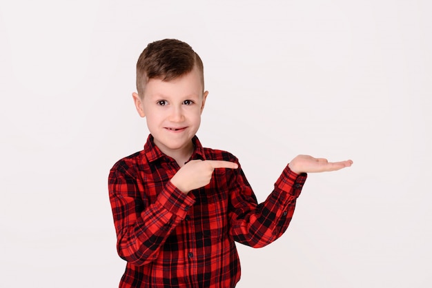 Der kleine Junge mit ausdrucksvollem Gefühl auf einem weißen Hintergrund.