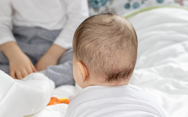 Der kleine Junge von hinten und sein großer Bruder vorne werden ihm einige Spielsachen für den Kleinkindbruder gezeigt