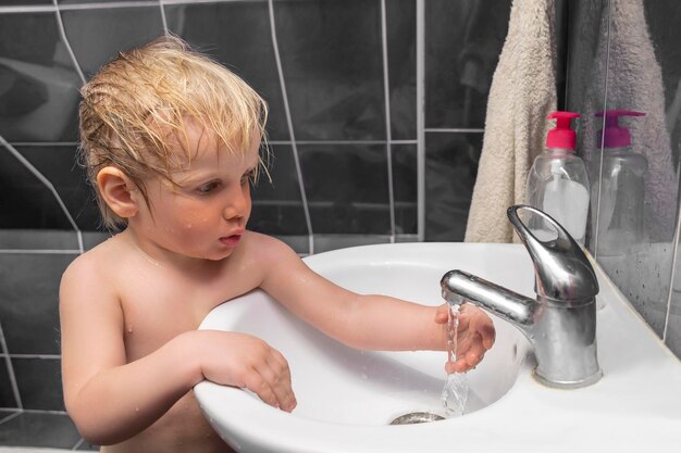 Der kleine Junge wäscht sich die Hände und putzt die Zähne im Badezimmer. Kind macht täglich Hygiene im Gesundheitswesen