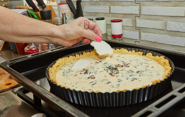 Der Koch bereitet Cheese Pie vor dem Backen im elektrischen Ofen vor