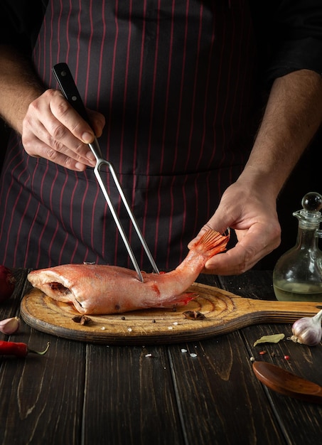 Der Koch bereitet Fisch Sebastes in der Hotelküche zu