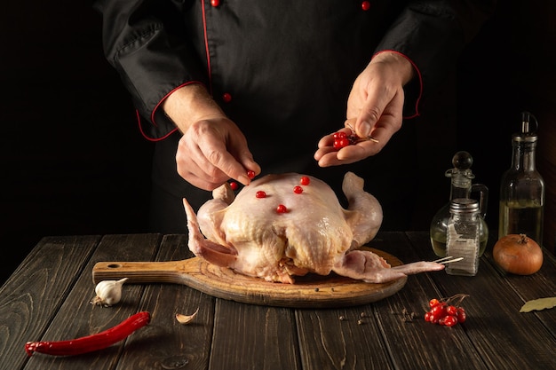 Der Koch fügt dem Masthähnchen vor dem Braten roten Schneeball hinzu