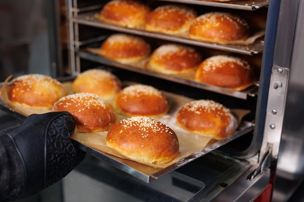 Der Koch nimmt Burgerbrötchen aus dem Ofen in der Küche des Restaurants