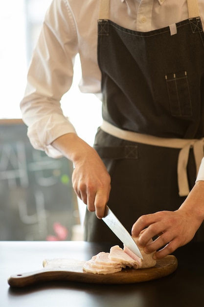 Der Koch schneidet das Fleisch.