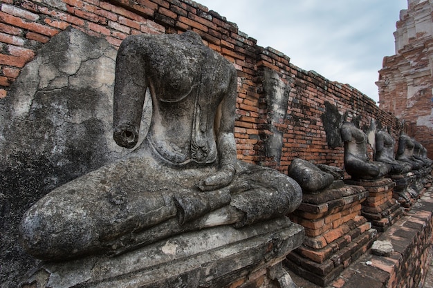 Der Körper einer steinernen Buddha-Statue auf einem alten Zaun im Chaiwatthanaram-Tempel Thailand