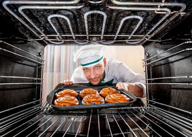 Der Küchenchef bereitet Gebäck im Ofen zu, Blick aus dem Inneren des Ofens. Kochen im Ofen.