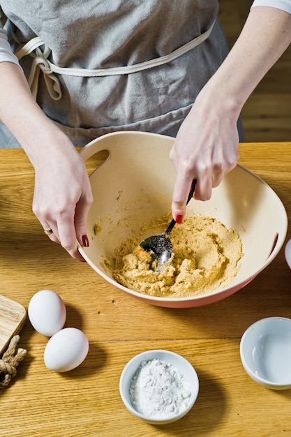 Der Küchenchef bereitet Haferkekse zu, mischt Rohrzucker und Butter. Zutaten Haferflocken, Butter, Zucker, Eier, Schokolade.