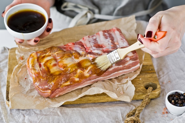 Der Küchenchef bereitet Schweinerippchen zum Grillen vor.